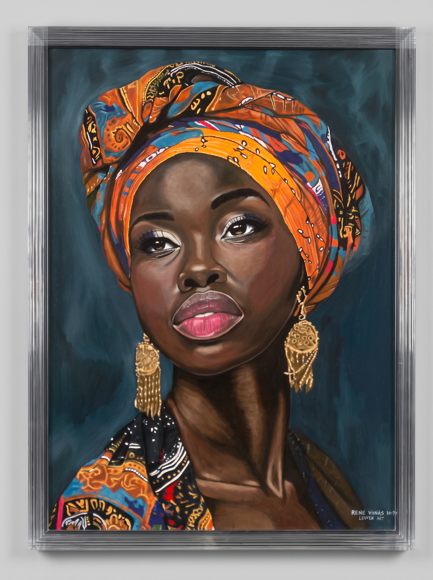 Ndifana Nomama — a portrait of an African woman in a vivid orange and blue headwrap with gold tassel earrings, in its original silver frame